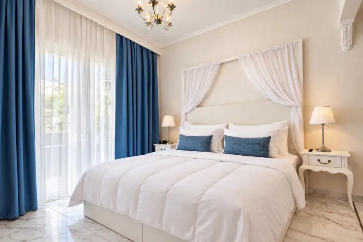 Aegean Spa Suite with indoor jacuzzi, sauna and rooftop jacuzzi, sea view – master bedroom with canopy drapes and blue curtains · Panorama Suites & Spa, Stomio