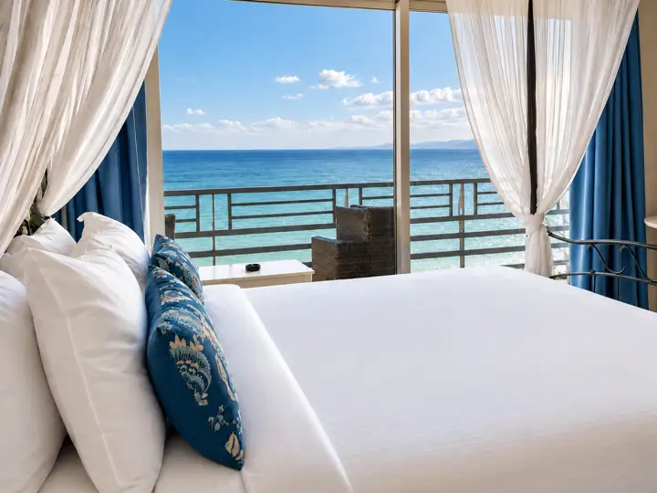 Blue Sky Suite with rooftop heated jacuzzi and sea-view hot tub – canopy bed facing floor-to-ceiling windows and the open sea · Panorama Suites & Spa, Stomio
