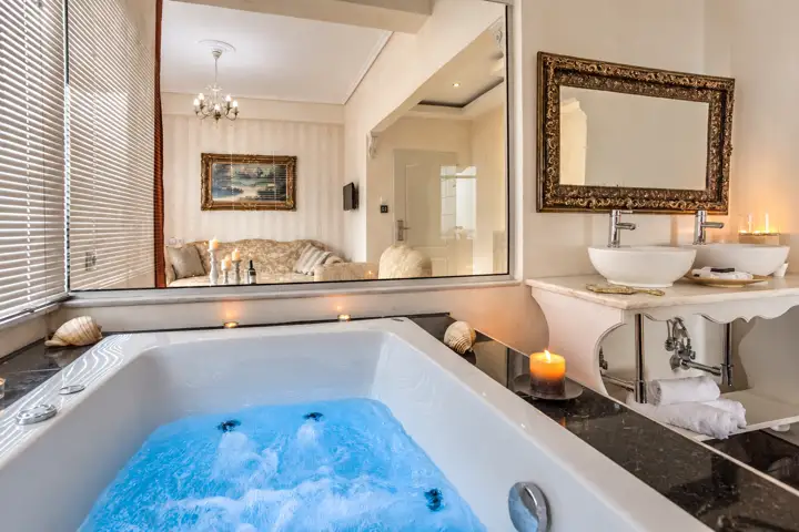 Blue Sky Suite with rooftop heated jacuzzi and sea-view hot tub – candlelit hot tub with double vanity and view into the living room · Panorama Suites & Spa, Stomio