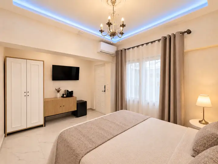 Sea Breeze Double Room with outdoor heated jacuzzi, sea view – bedroom with marble floors, ambient ceiling lighting, wardrobe and coffee station · Panorama Suites & Spa, Stomio
