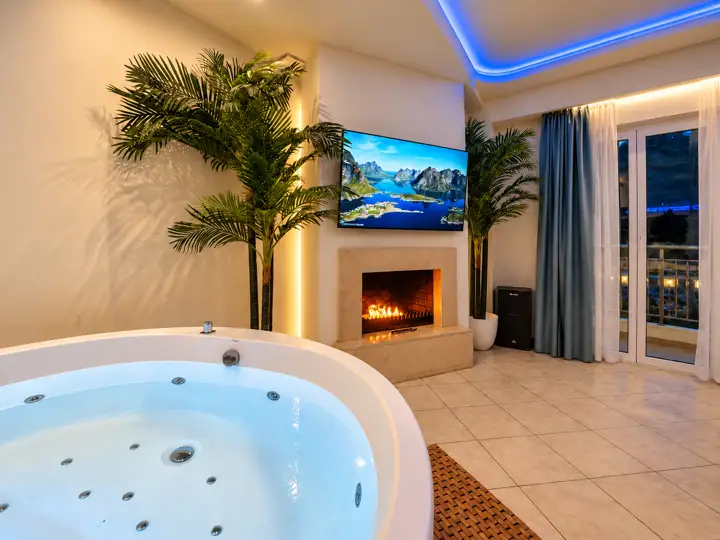 Ethereal Suite with indoor jacuzzi and fireplace – indoor jacuzzi by the lit fireplace in the evening · Panorama Suites & Spa, Stomio