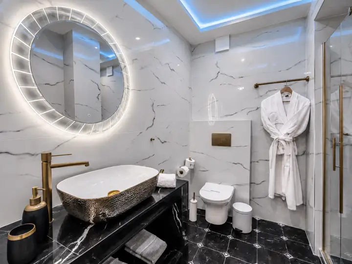 Ethereal Suite with indoor jacuzzi and fireplace – marble bathroom with gold vessel sink and glass shower · Panorama Suites & Spa, Stomio