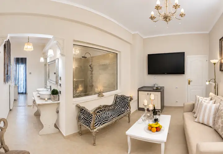 Horizon Suite with indoor and outdoor jacuzzi, sea view – living room with view into the rain shower · Panorama Suites & Spa, Stomio