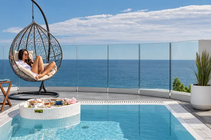 Infinity Suite with private heated pool, jacuzzi and sauna, sea view – hanging chair by the private heated pool with open sea view · Panorama Suites & Spa, Stomio