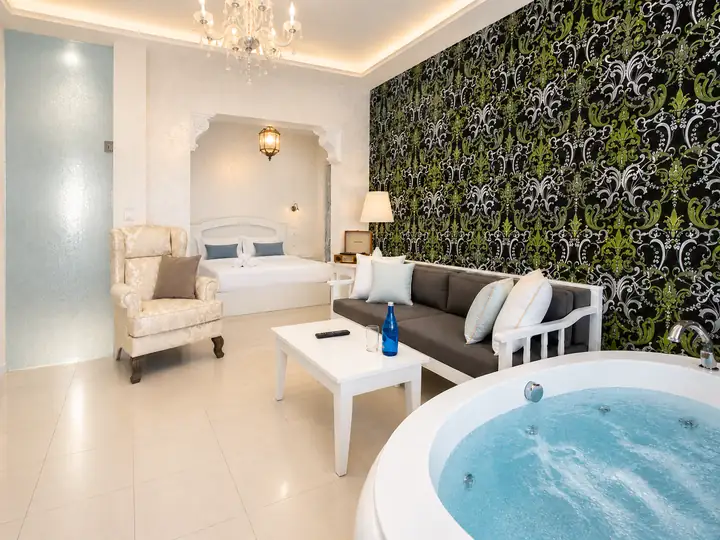 Infinity Suite with private heated pool, jacuzzi and sauna, sea view – spacious living area with indoor jacuzzi and double bed · Panorama Suites & Spa, Stomio