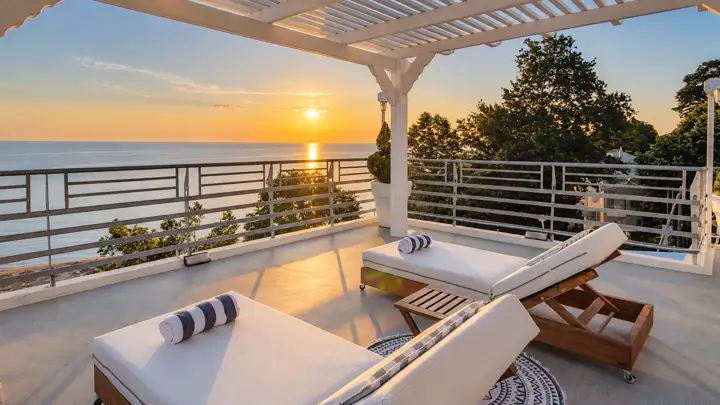 Master Sky Suite with heated jacuzzi, sauna and rooftop terrace, sea view – sun-lounger pavilion on the 120 m² terrace at sunrise over the sea · Panorama Suites & Spa, Stomio