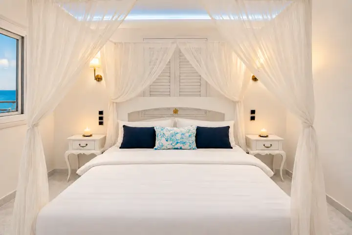 Master Sky Suite with heated jacuzzi, sauna and rooftop terrace, sea view – bedroom with canopy bed and sea-view window · Panorama Suites & Spa, Stomio
