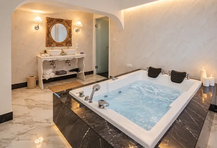 Sunrise Suite with two bedrooms, heated infinity pool and jacuzzi, sea view – indoor jacuzzi for two with marble surround and double vanity · Panorama Suites & Spa, Stomio