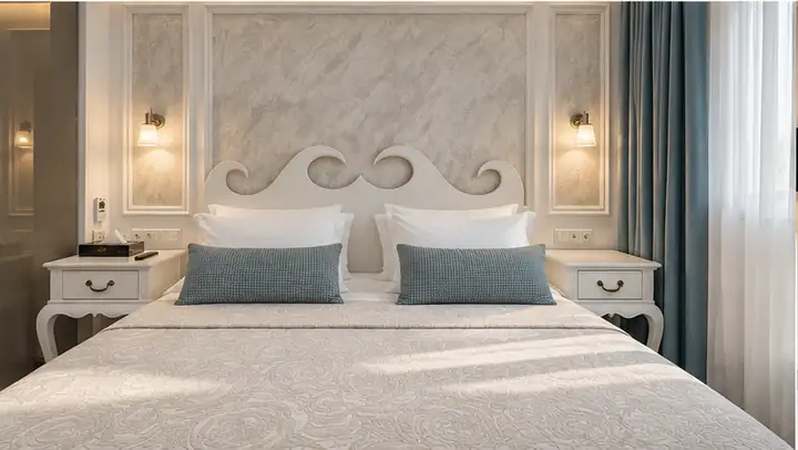 Sunrise Suite with two bedrooms, heated infinity pool and jacuzzi, sea view – double bed with ornate headboard · Panorama Suites & Spa, Stomio