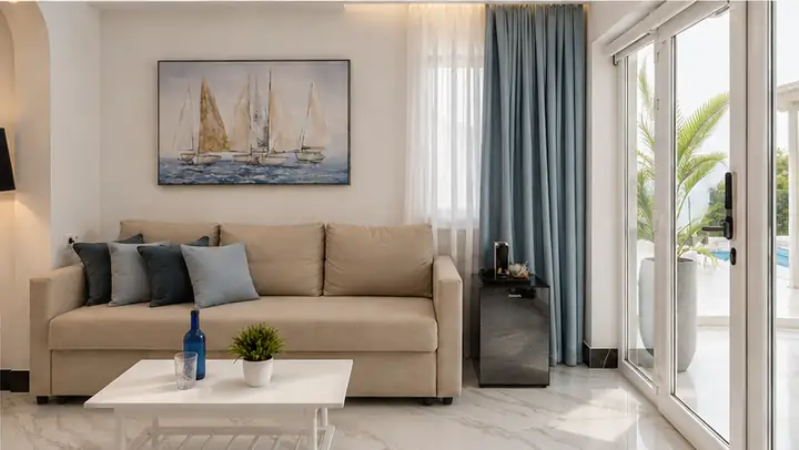 Sunrise Suite with two bedrooms, heated infinity pool and jacuzzi, sea view – living room with sofa bed and terrace door · Panorama Suites & Spa, Stomio